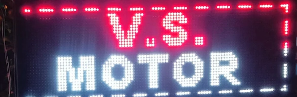 The illuminated V.S. Motor LED sign outside the office at night